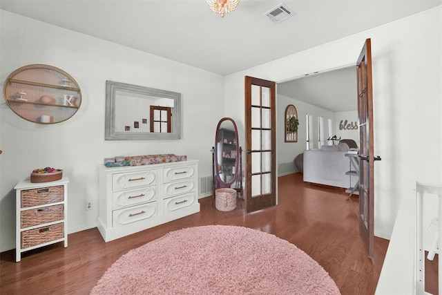 bedroom with french doors and dark hardwood / wood-style floors