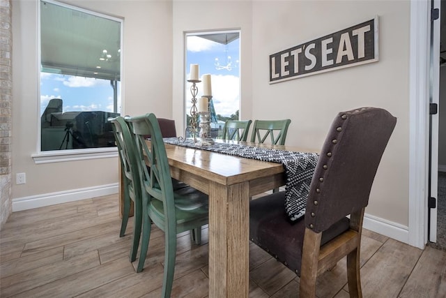 dining area featuring wood-type flooring and an inviting chandelier