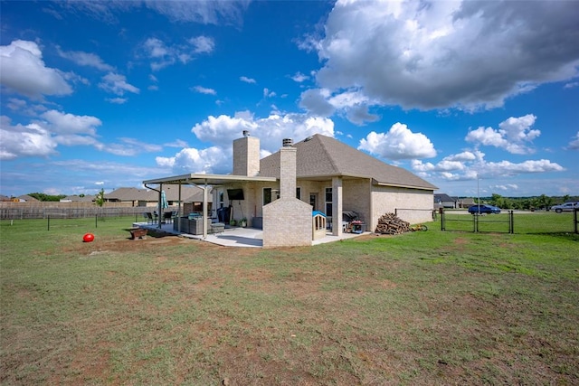 back of property with a lawn and a patio area