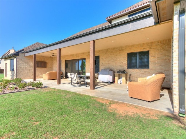 rear view of property featuring outdoor lounge area, ceiling fan, a patio area, and a lawn