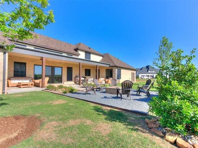 back of property with an outdoor living space with a fire pit, a lawn, and a patio