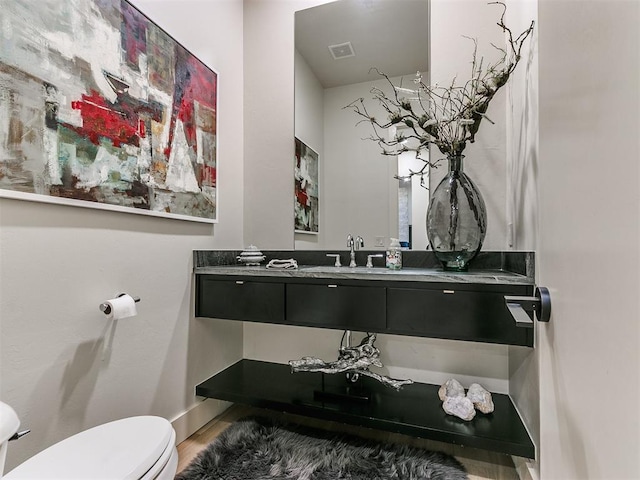 bathroom featuring hardwood / wood-style floors, vanity, and toilet