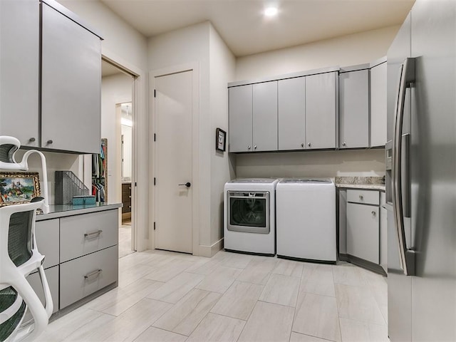 laundry area with washer and dryer and cabinets