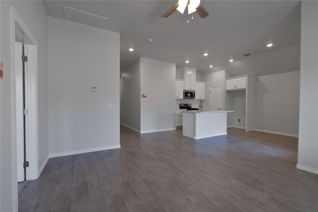 unfurnished living room with wood-type flooring and ceiling fan