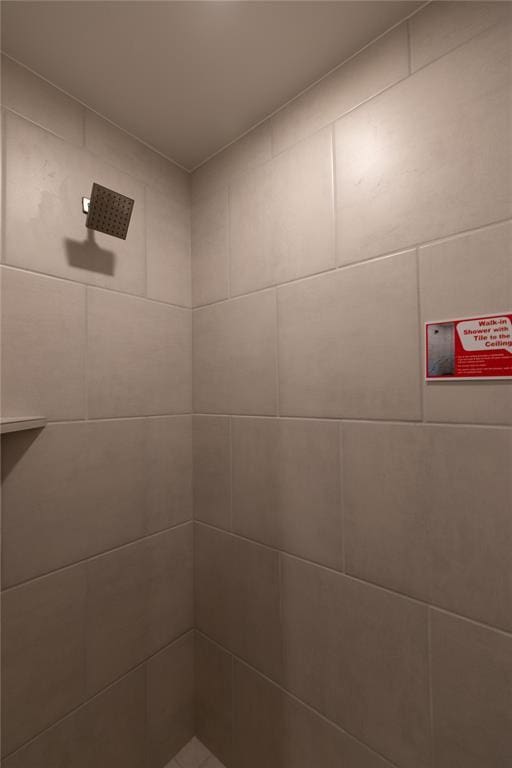 interior details with a tile shower