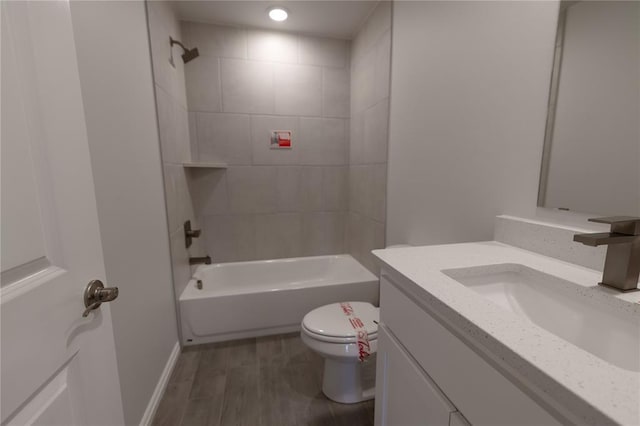 full bathroom featuring vanity, toilet, wood-type flooring, and tiled shower / bath