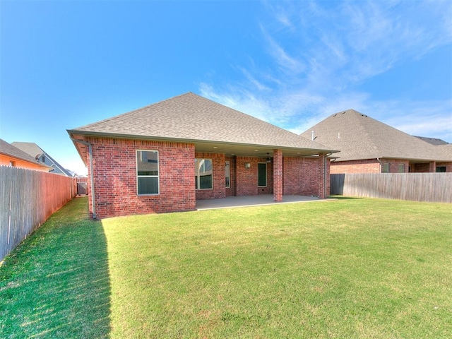 rear view of house with a lawn and a patio