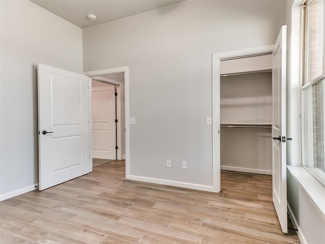 unfurnished bedroom featuring light hardwood / wood-style flooring and a closet