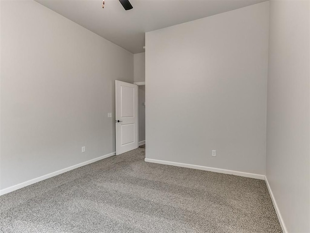 carpeted spare room featuring ceiling fan