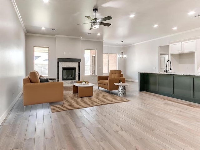 unfurnished living room featuring plenty of natural light, light wood-type flooring, and ornamental molding