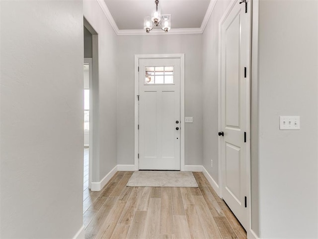 foyer entrance with light wood-type flooring, crown molding, and a chandelier