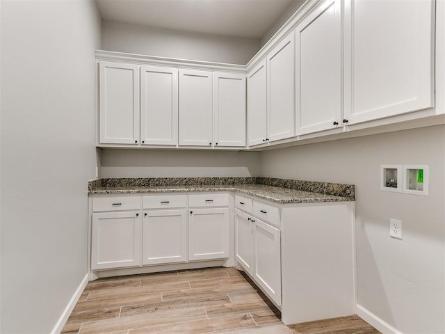 laundry area featuring washer hookup, cabinets, and light hardwood / wood-style floors