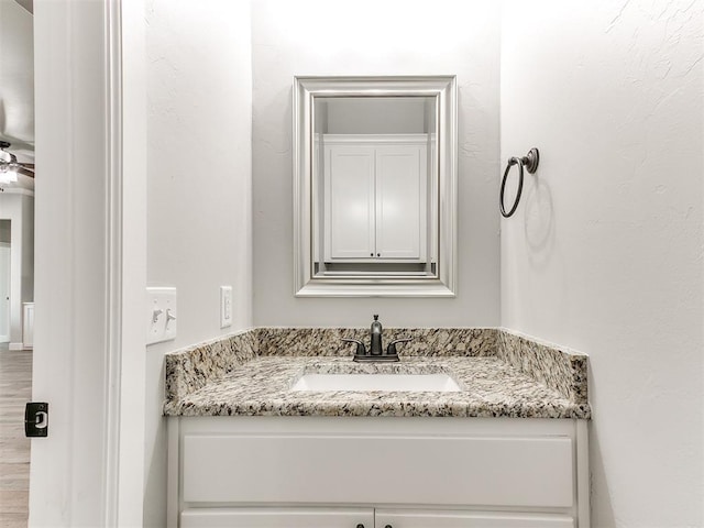 bathroom featuring ceiling fan, hardwood / wood-style floors, and vanity