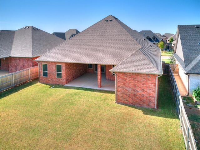 rear view of property featuring a patio and a lawn