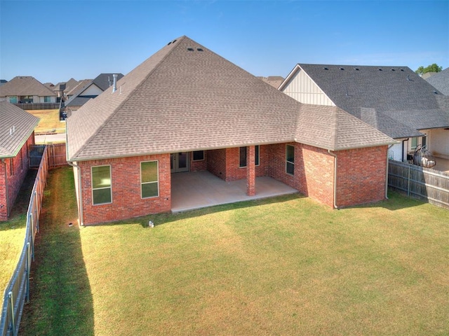 back of property with a patio area and a yard