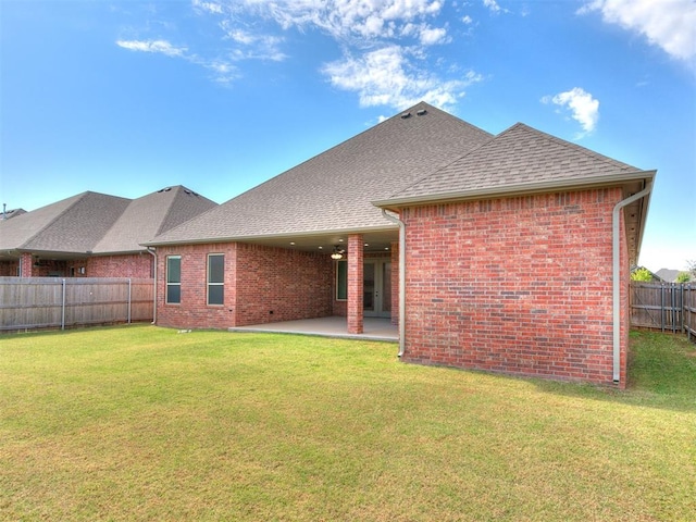 rear view of house with a lawn and a patio area