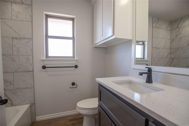 full bathroom with shower / bathing tub combination, vanity, hardwood / wood-style flooring, and toilet