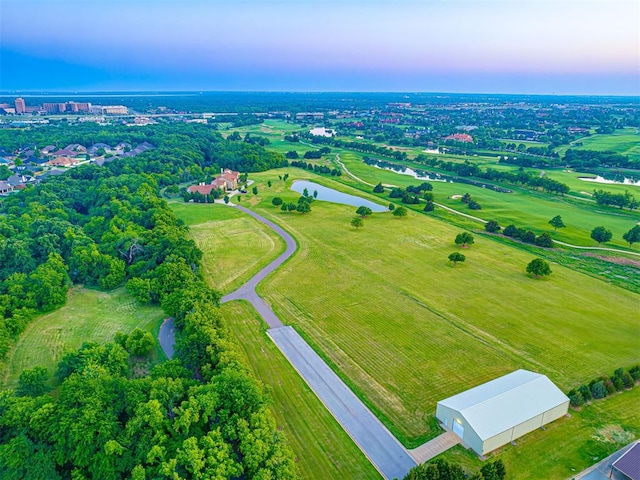 aerial view at dusk with a rural view and a water view