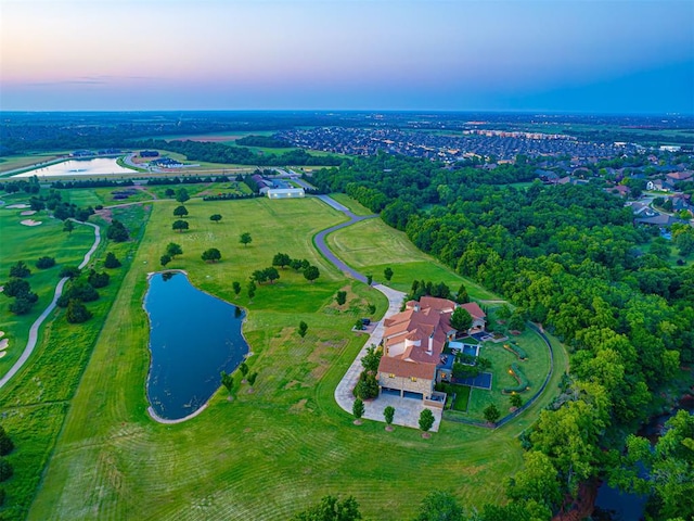 aerial view at dusk featuring a water view