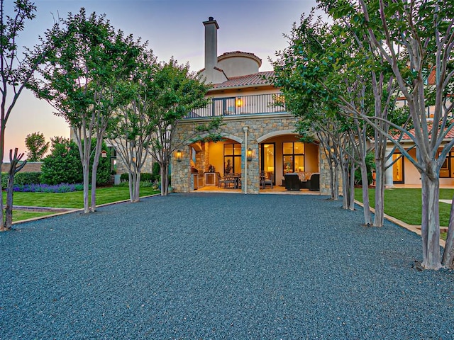 view of front of home featuring a yard, outdoor lounge area, a balcony, and a patio