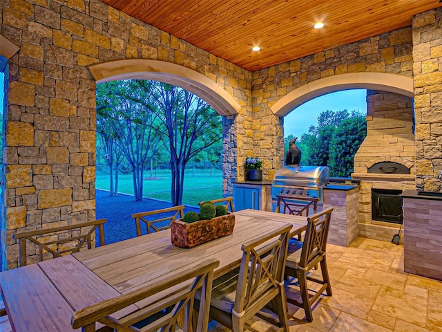 unfurnished dining area featuring a wealth of natural light, a water view, wood ceiling, and an outdoor stone fireplace