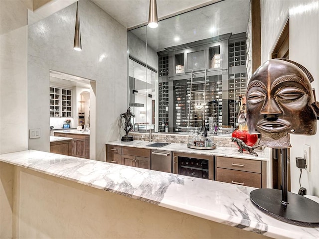 bar featuring sink, wine cooler, and light stone counters