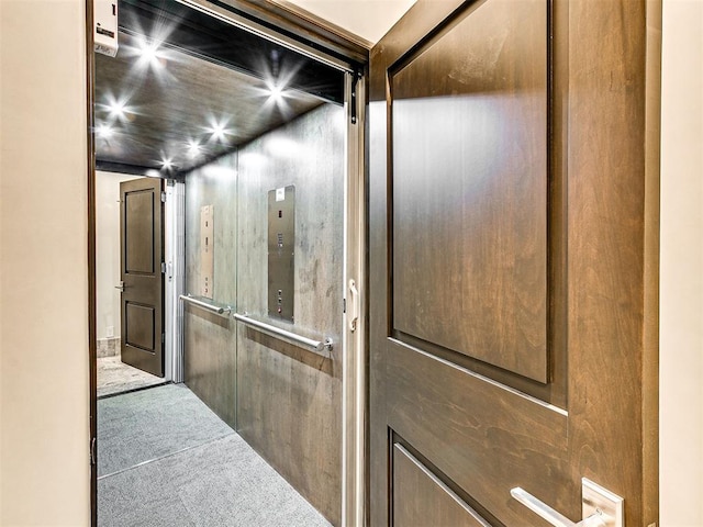 hallway with carpet flooring and elevator