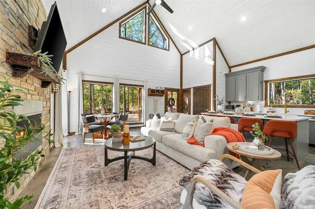 living room with wooden ceiling, high vaulted ceiling, and a healthy amount of sunlight