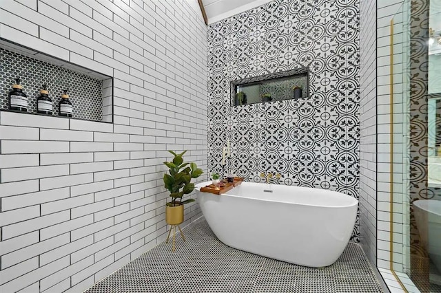 bathroom with a bathing tub and tile walls