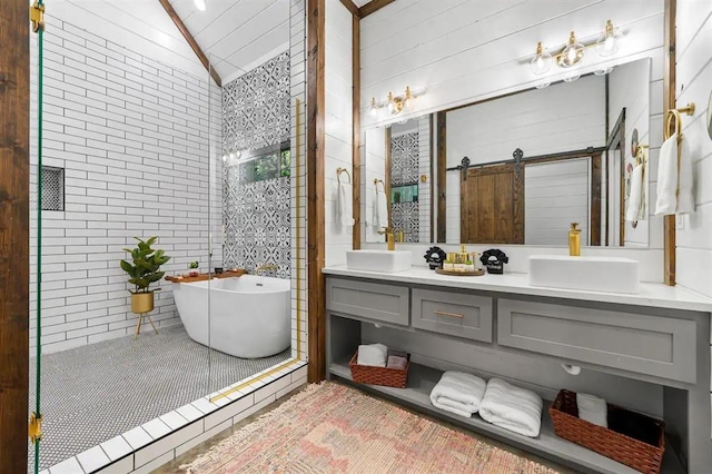 bathroom featuring a washtub, vanity, vaulted ceiling, and tile walls