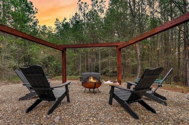 patio terrace at dusk featuring an outdoor fire pit