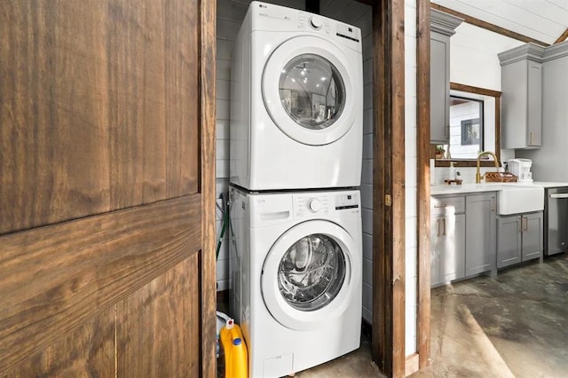 laundry room featuring sink and stacked washer and dryer