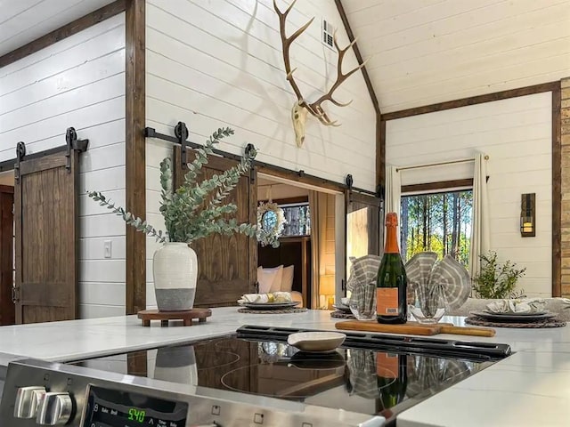 interior space with wood walls, a barn door, and stove