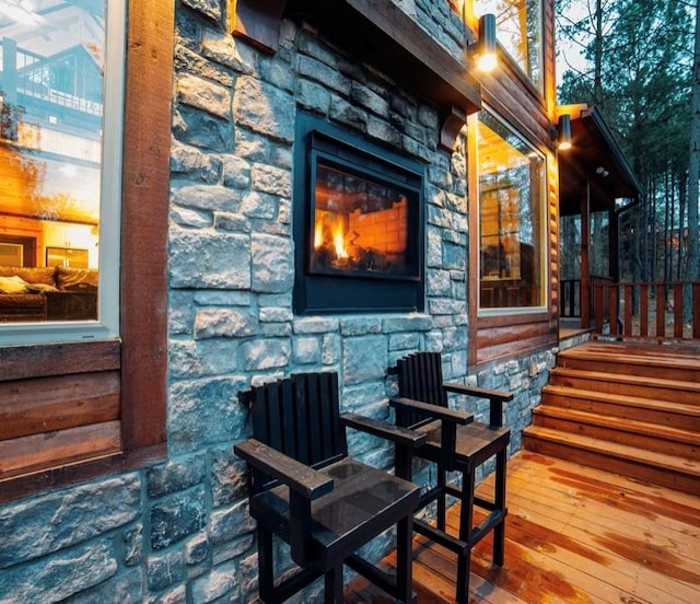 wooden deck featuring a stone fireplace