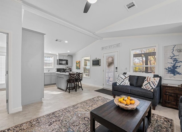 tiled living room with ceiling fan and vaulted ceiling