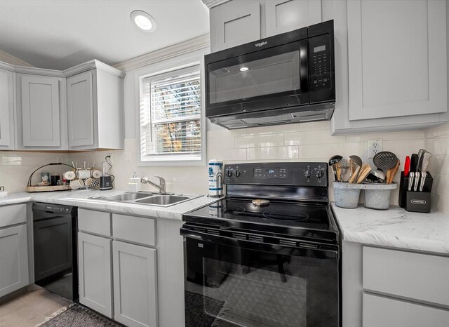 kitchen featuring light stone countertops, backsplash, gray cabinetry, sink, and black appliances