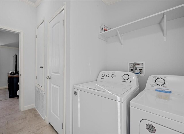 washroom with washer and clothes dryer and ornamental molding