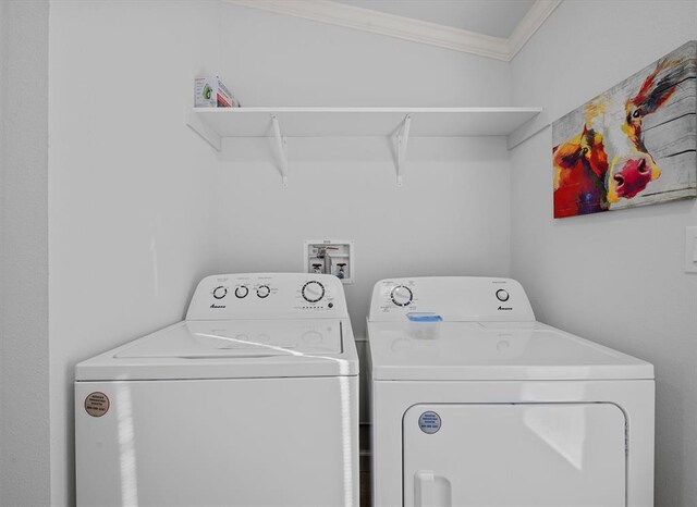 laundry area featuring washing machine and clothes dryer and crown molding