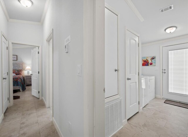 hall with washing machine and clothes dryer and ornamental molding