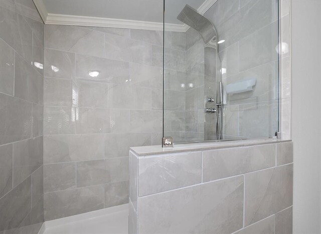 bathroom with a tile shower and ornamental molding