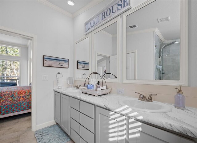 bathroom with tile patterned floors, crown molding, vanity, and walk in shower