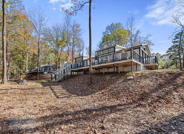 back of house featuring a wooden deck and a sunroom