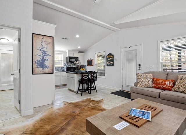 living room featuring lofted ceiling with beams and ornamental molding