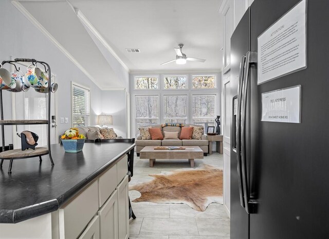 kitchen featuring ceiling fan, white cabinetry, stainless steel refrigerator with ice dispenser, and ornamental molding