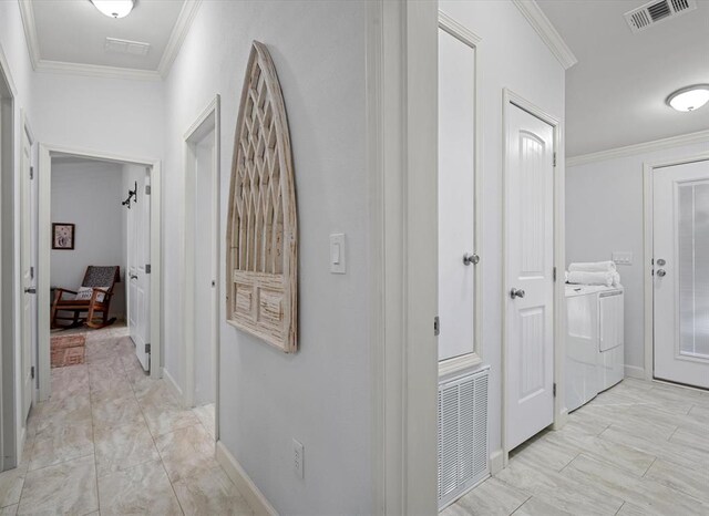 hall with washing machine and dryer and crown molding