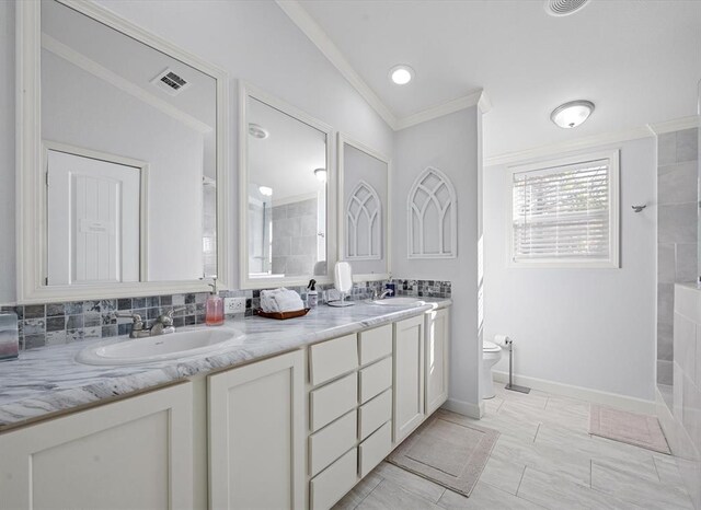 bathroom featuring ornamental molding, vanity, toilet, and lofted ceiling