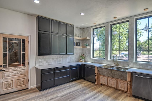 kitchen featuring decorative light fixtures, dishwasher, black dishwasher, decorative backsplash, and light hardwood / wood-style flooring