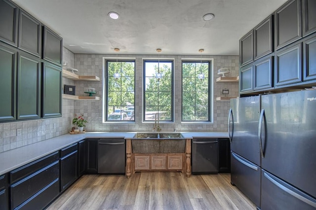 kitchen with appliances with stainless steel finishes, decorative light fixtures, sink, and plenty of natural light