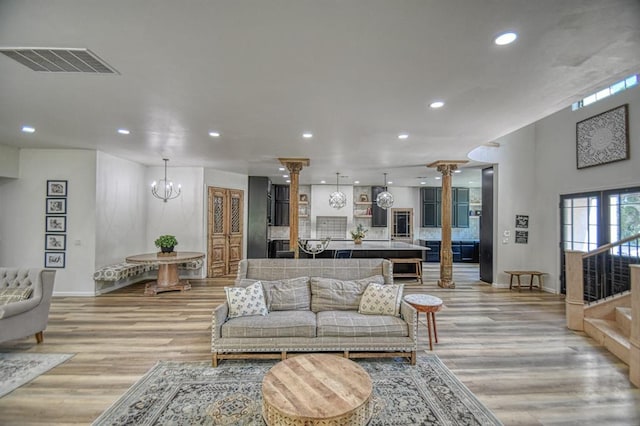 living room featuring light hardwood / wood-style flooring and decorative columns