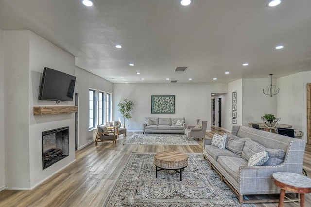 living room with hardwood / wood-style floors and a notable chandelier